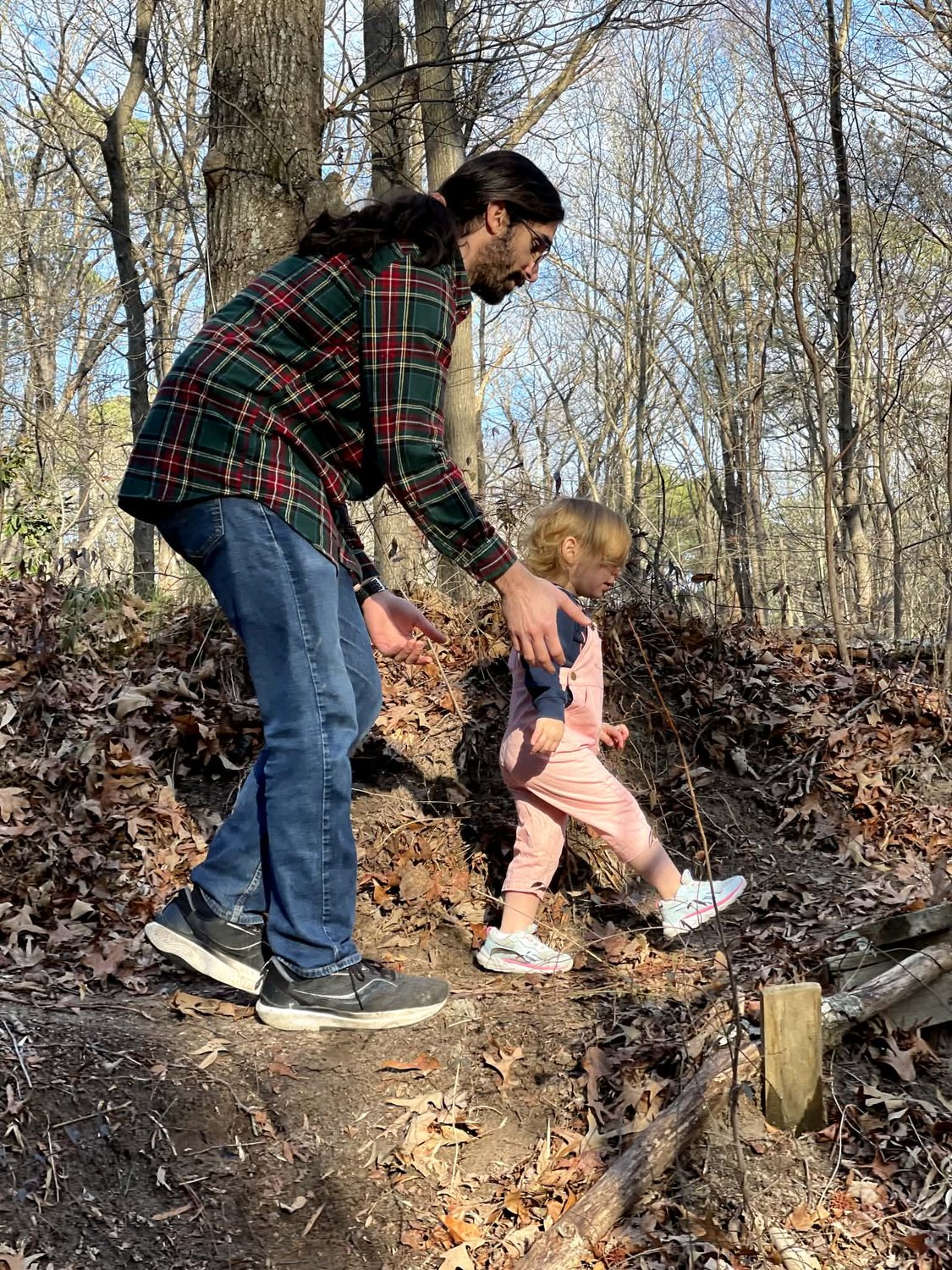 Ozan Duran walking through the woods with his child